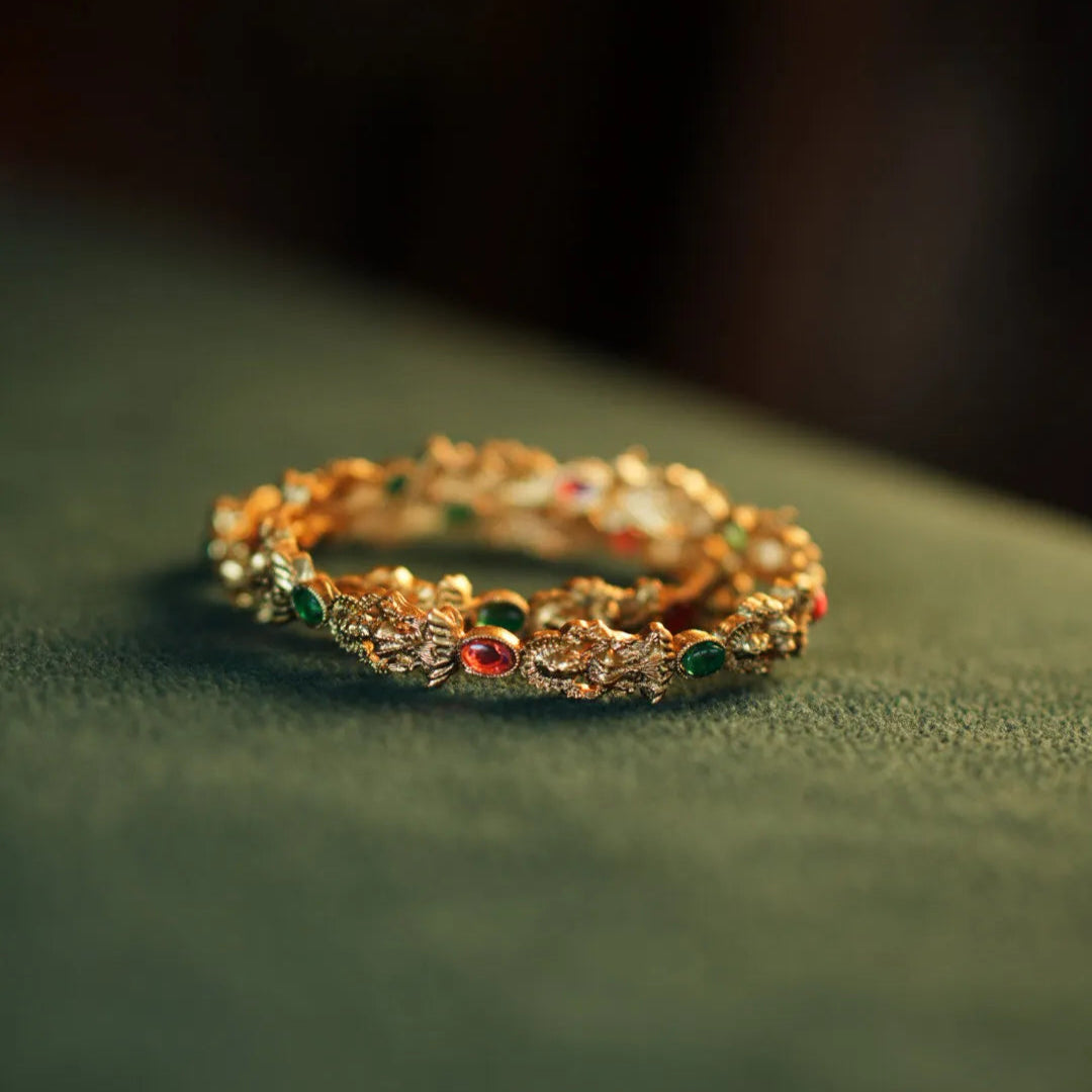 Gold ring with gemstones on a green surface