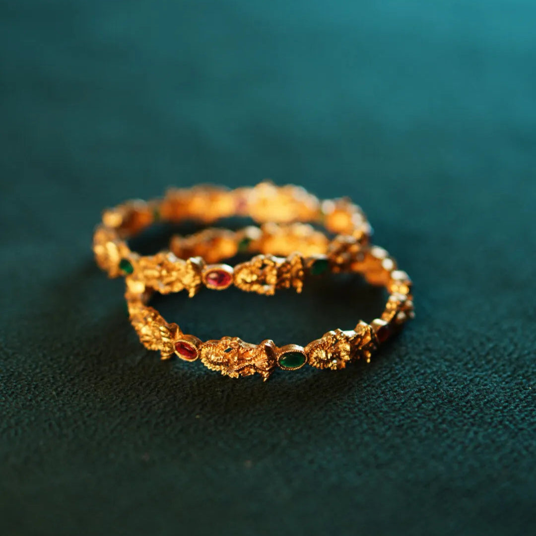 Gold bracelet on a green fabric background