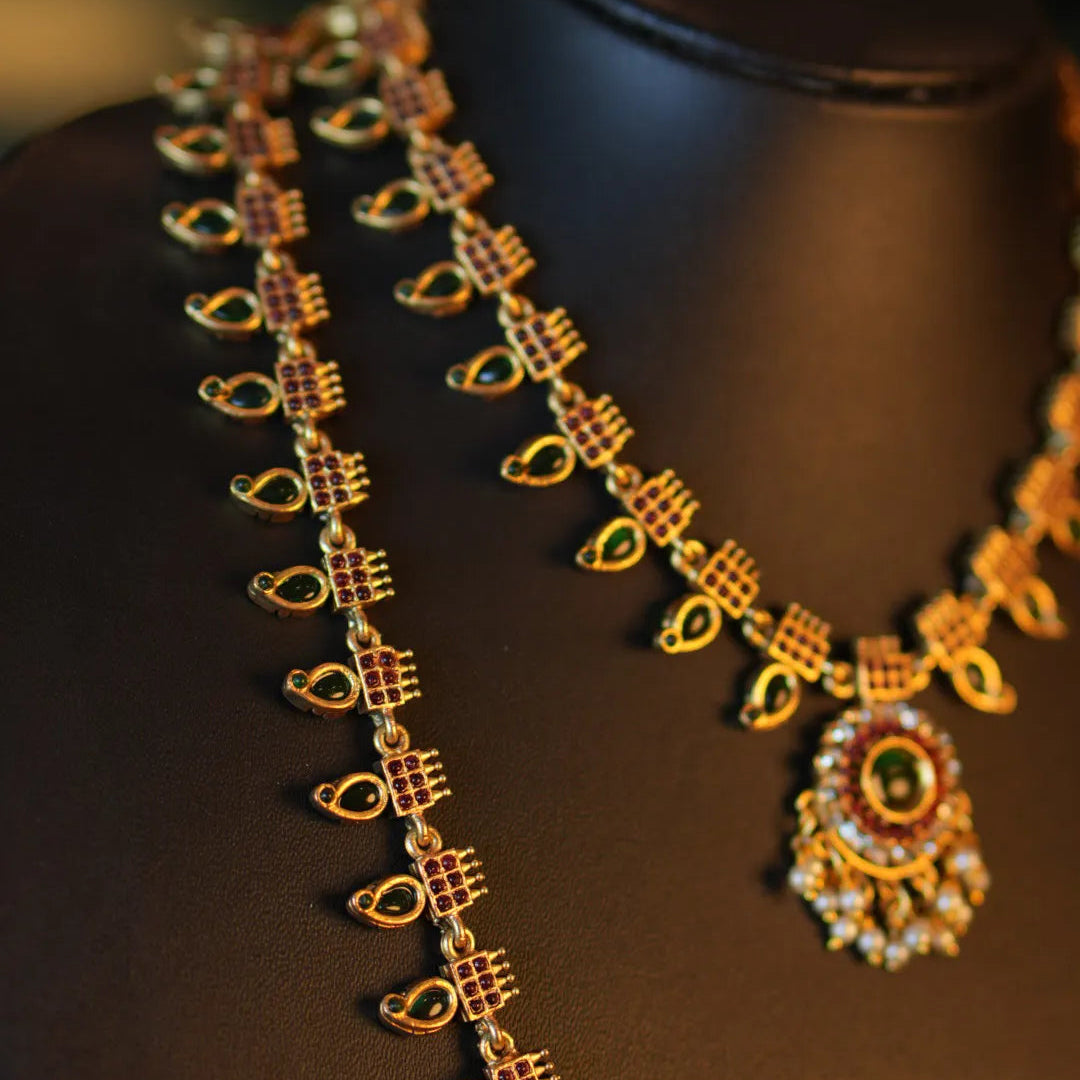 Gold necklace with pendant on a dark mannequin