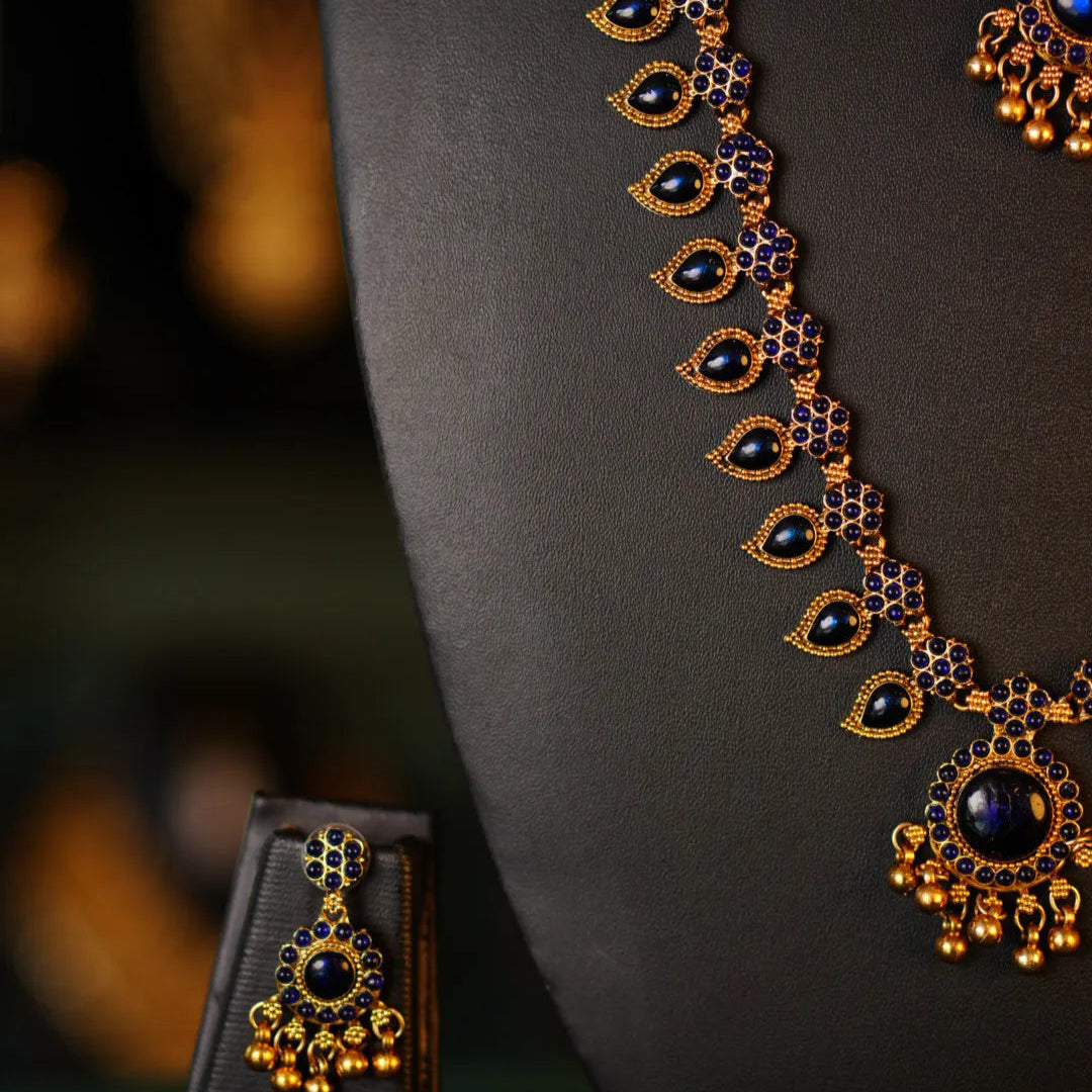 Decorative necklace with black stones and gold accents on a dark background