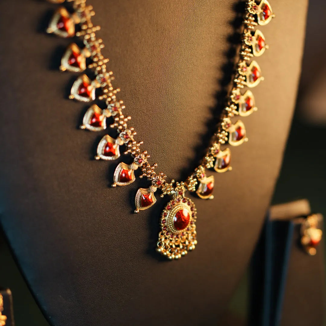 Gold necklace with red stones on a mannequin bust