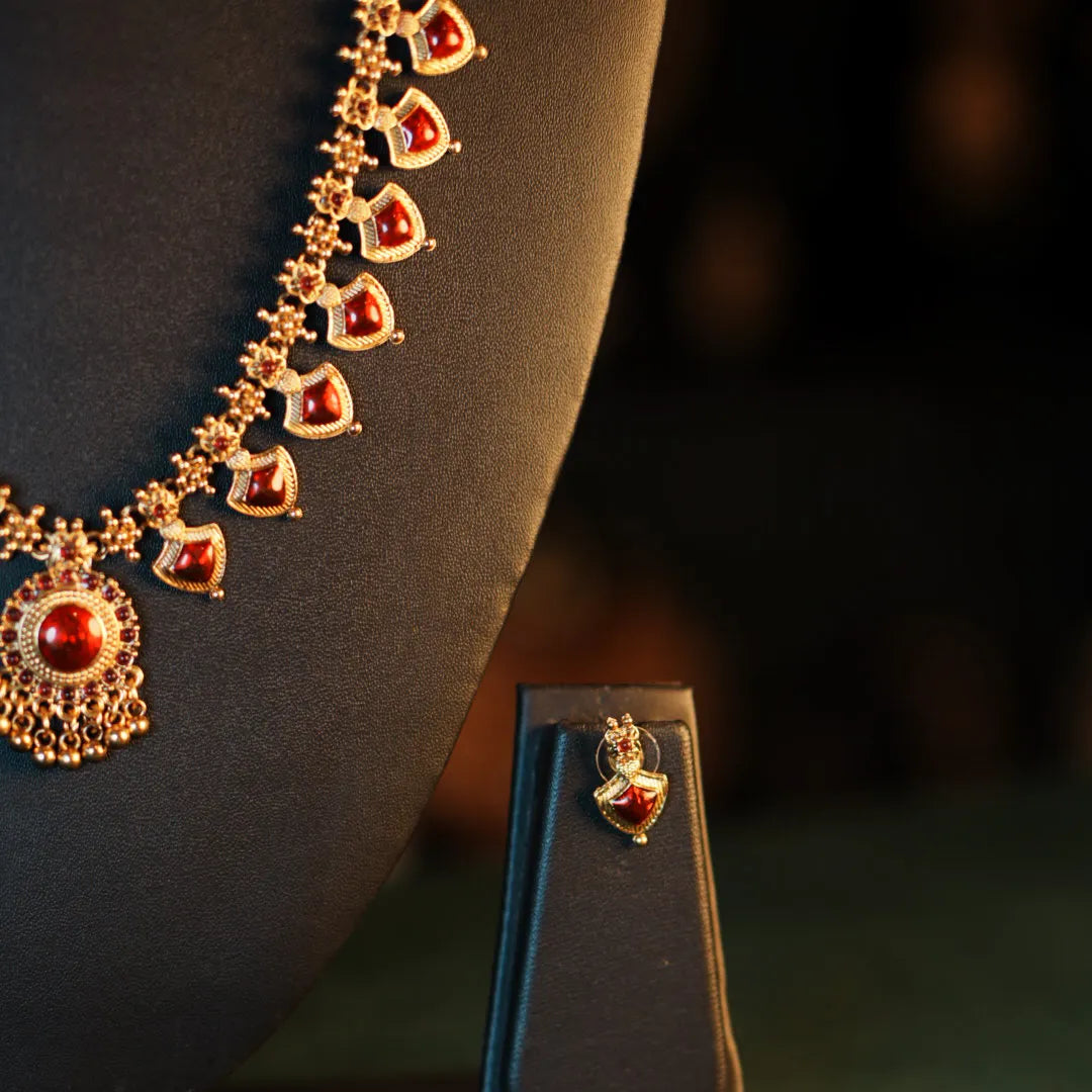 Gold necklace with red stones on a dark background