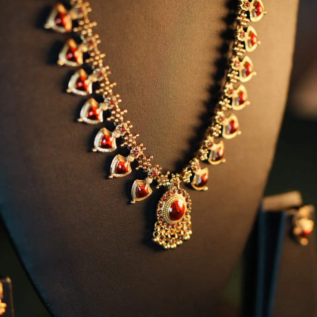 Decorative necklace with red stones on a dark background