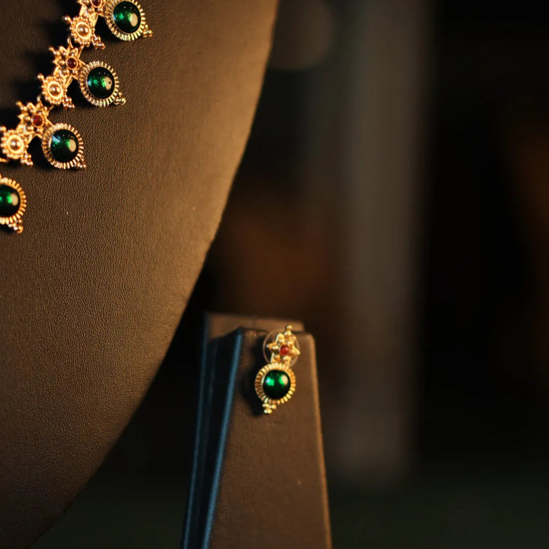 Gold and green jewelry on a dark background
