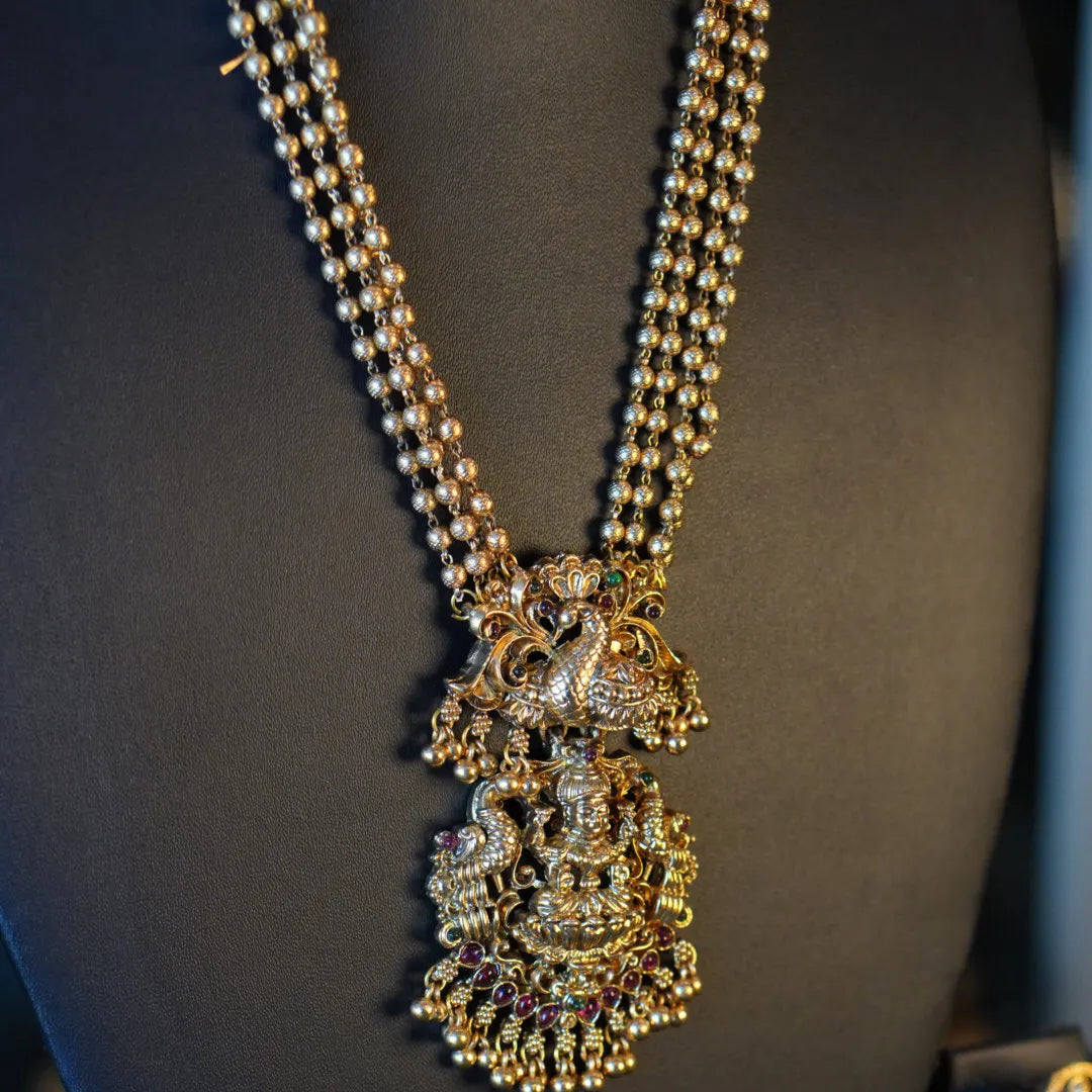 Decorative necklace with intricate design on a mannequin bust