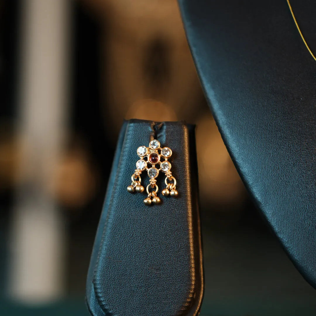 Blue leather strap with decorative gold charm on a blurred background