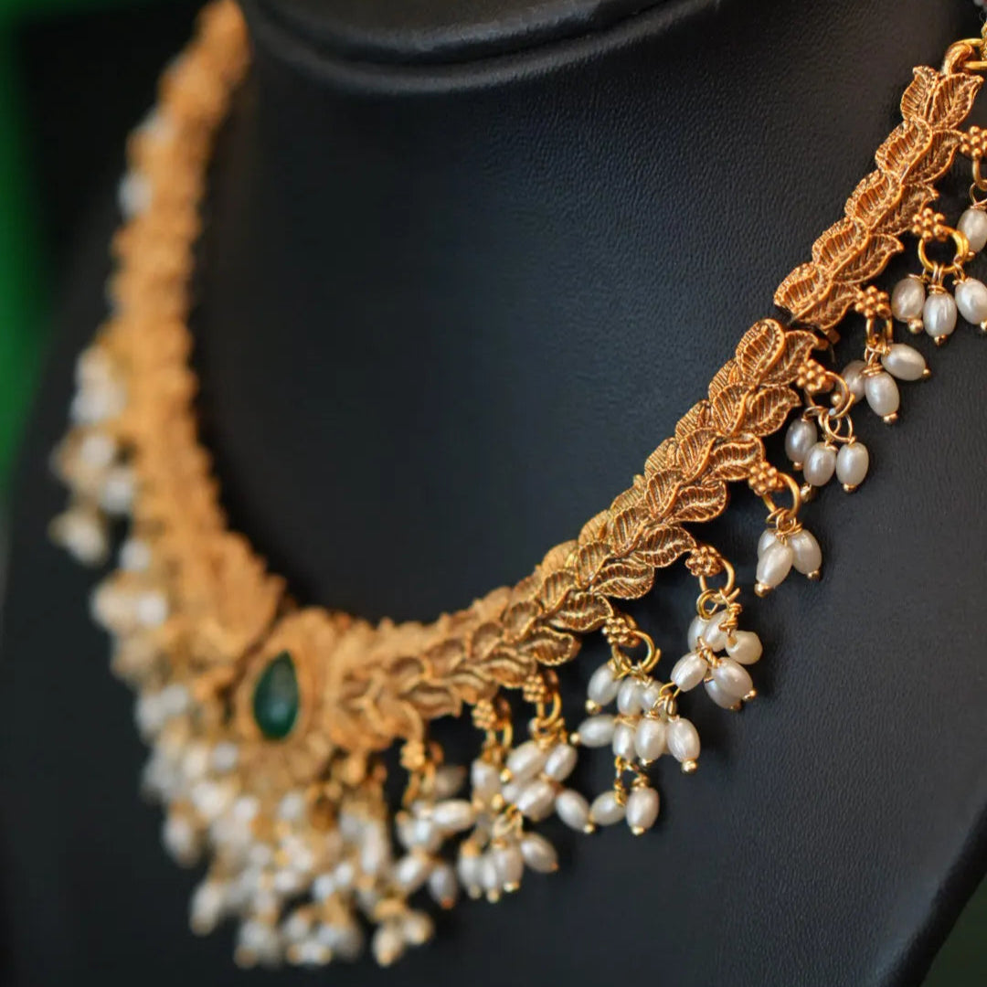 Gold necklace with pearls on a black mannequin