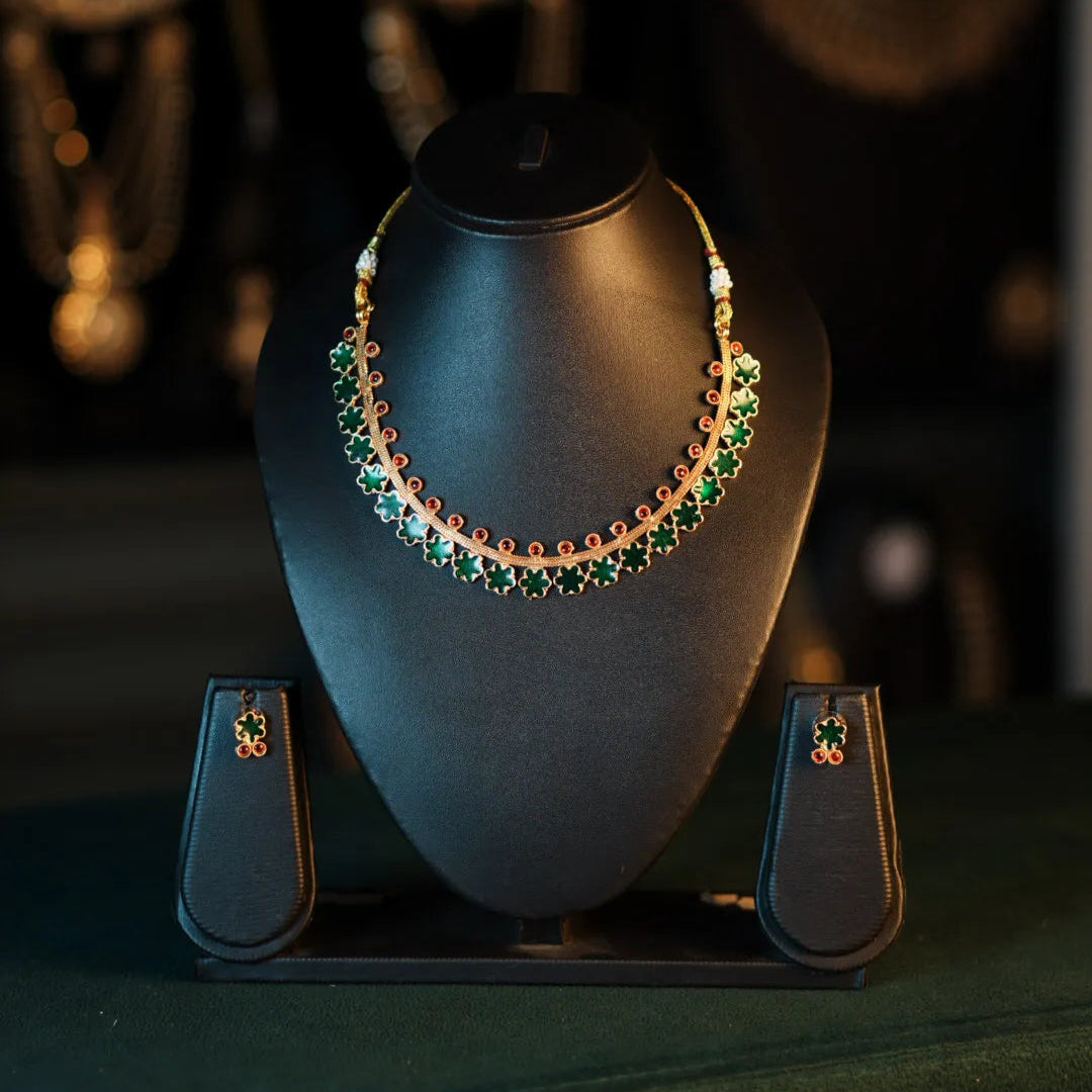 Necklace with green gemstones on a black stand with blurred background