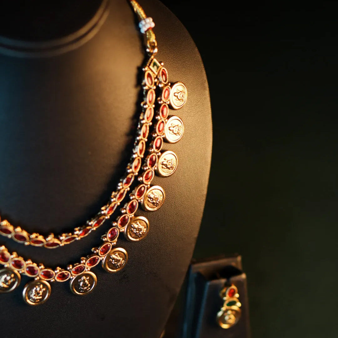 Gold necklace on a black mannequin with a dark background