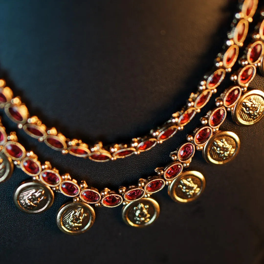 Gold necklace with red stones on a dark background