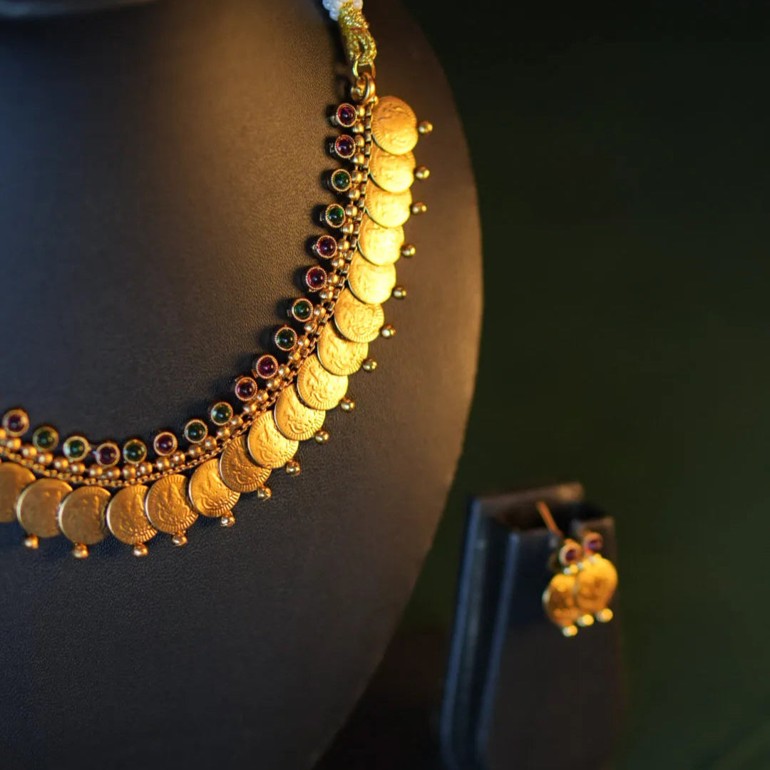 Gold necklace with coins on a dark background