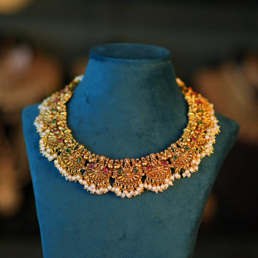 Decorative necklace on a blue mannequin bust with a blurred background