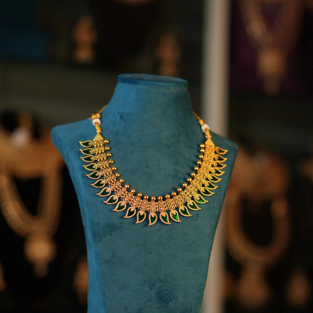 Gold necklace on a blue stand with blurred background