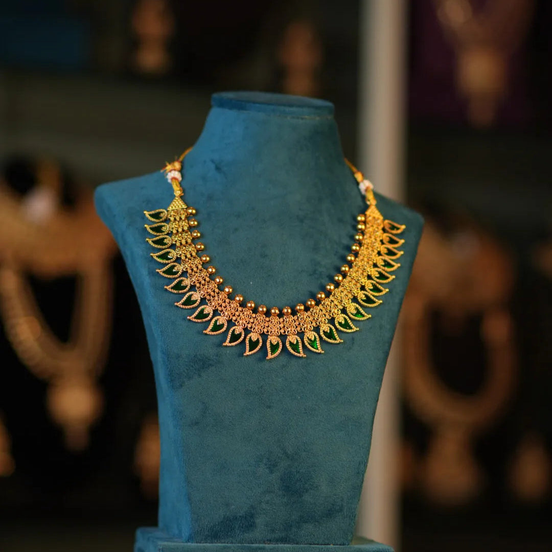 Gold necklace on a blue mannequin against a blurred background
