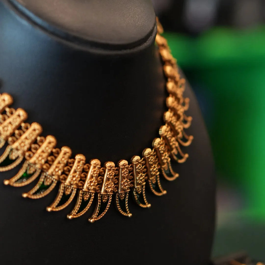 Gold necklace on a black surface with a blurred background