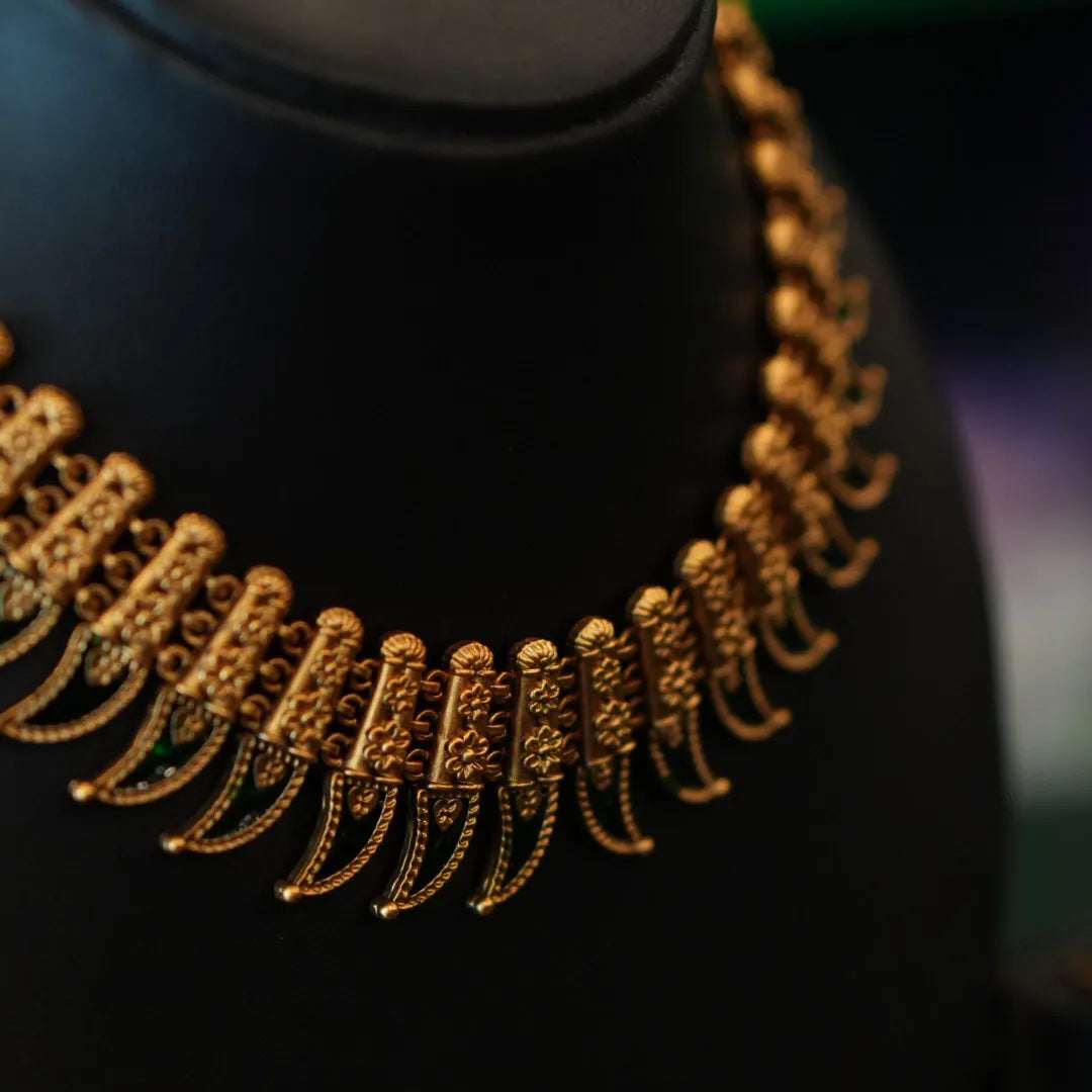 Gold necklace on a black mannequin