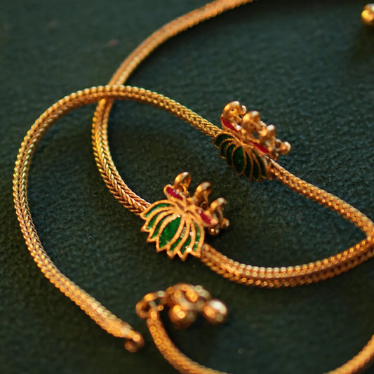 Gold bracelet with decorative elements on a dark green background