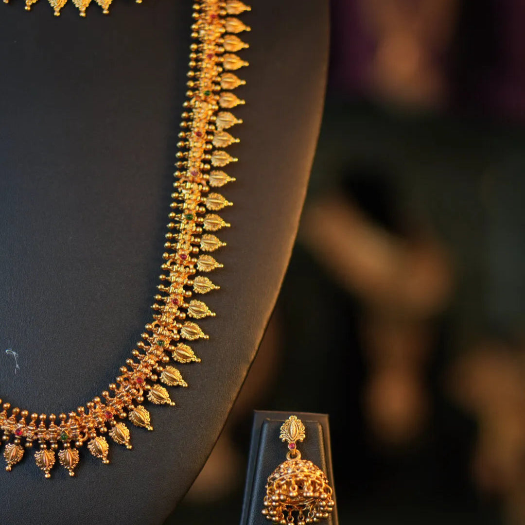 Gold necklace and earrings on a dark background