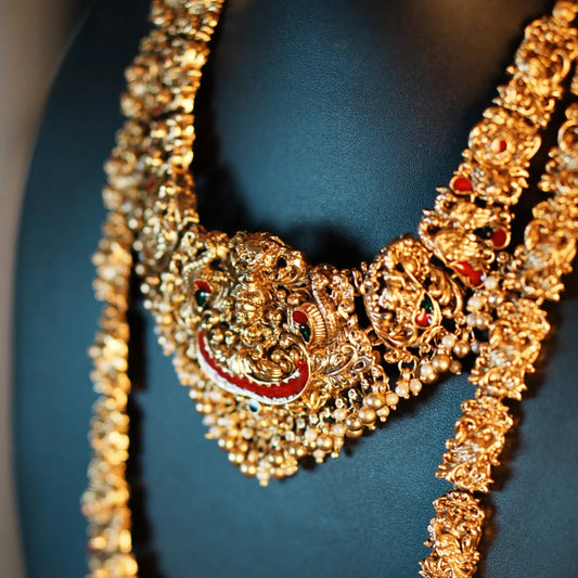 Gold necklace with intricate design on a dark background