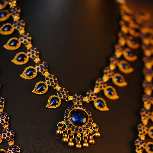 Ornate gold and blue necklace on a dark background