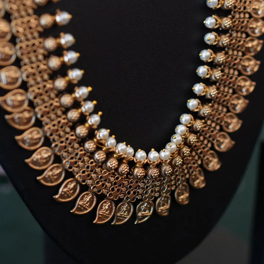 Gold and pearl necklace on a black background