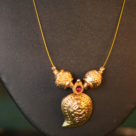 Gold necklace with a pendant on a black background