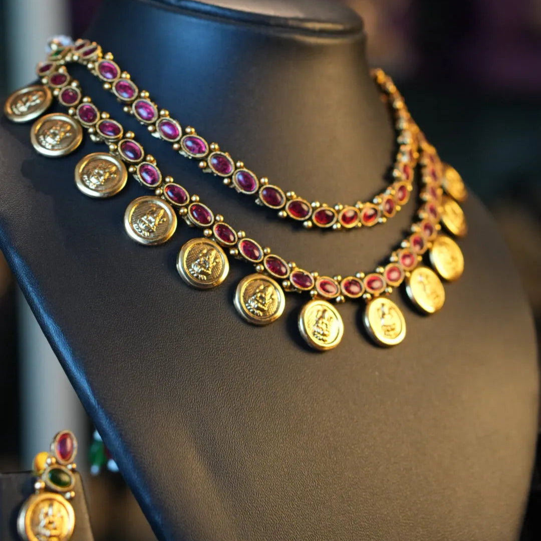 Gold necklace with gemstones on a mannequin bust against a blurred background