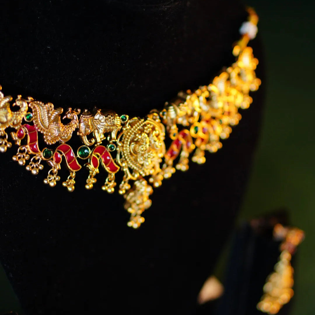 Gold necklace with intricate designs on a black background