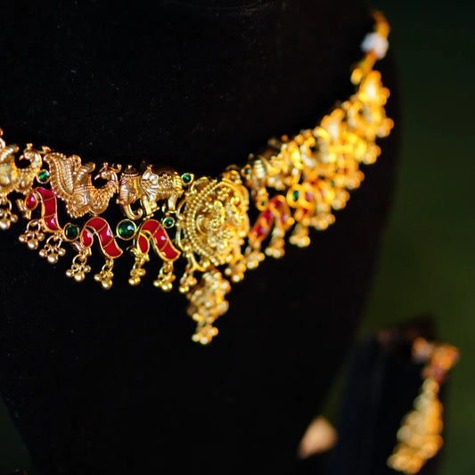 Gold necklace with intricate designs on a black background