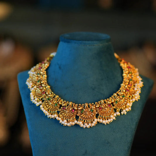 Gold necklace on a blue mannequin bust with a blurred background