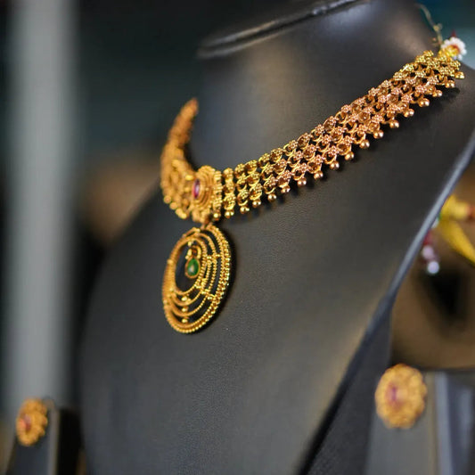 Gold necklace on a black mannequin head with a blurred background