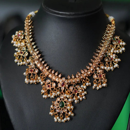 Ornate necklace on a black mannequin with a blurred green background
